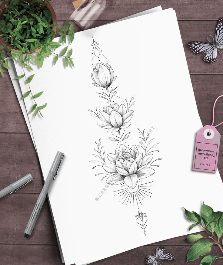 a paper with flowers and butterflies on it next to some pens, scissors and a plant