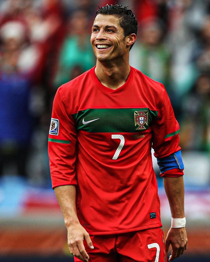 a soccer player smiles as he stands in front of the crowd during a match between portugal and mexico