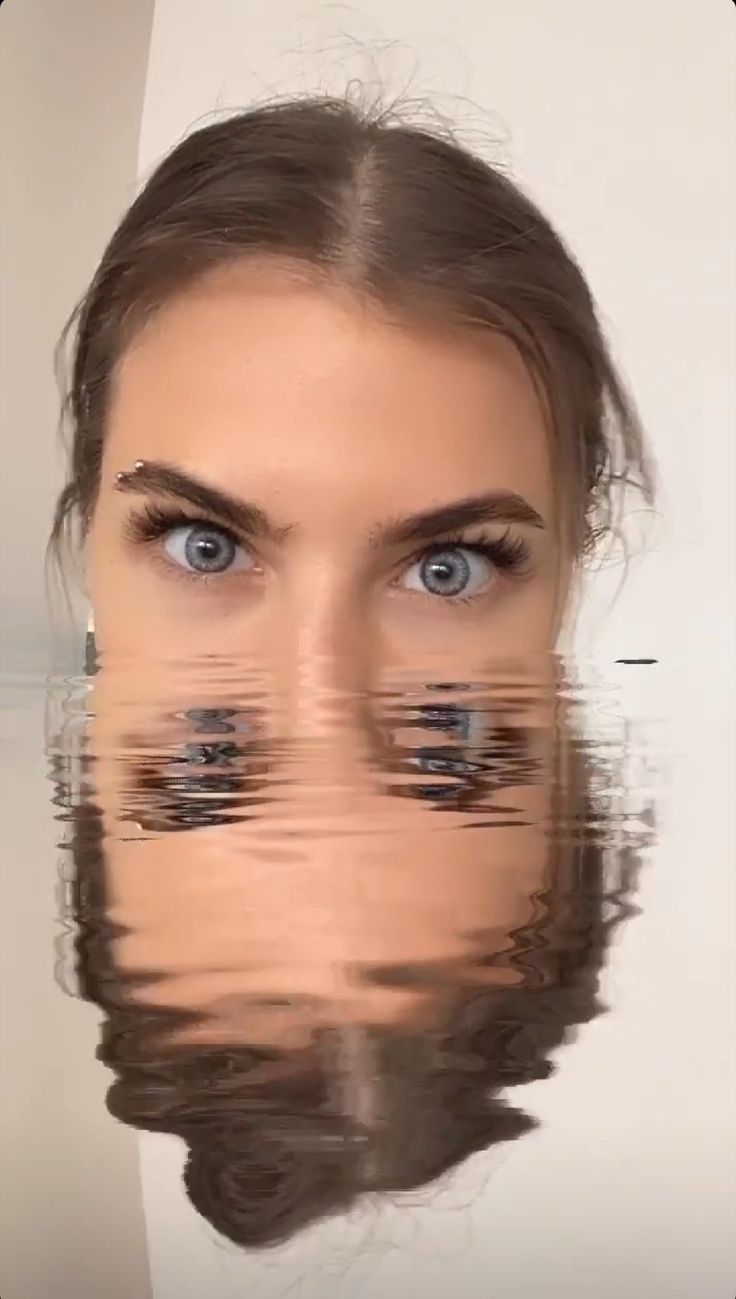 a woman's face is reflected in water