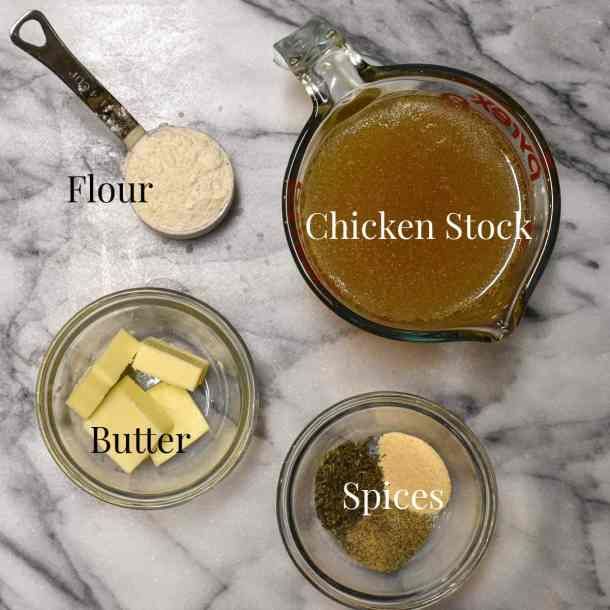 ingredients for chicken stock in glass bowls on a marble counter