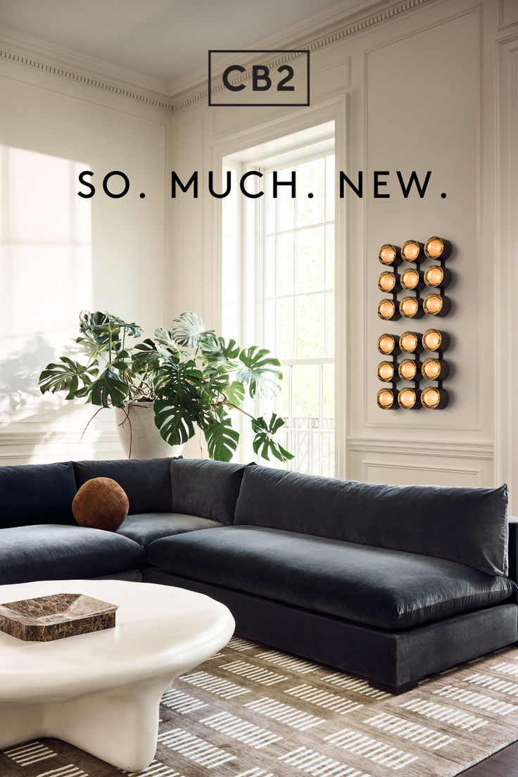 a living room with a large black couch and white coffee table in front of it