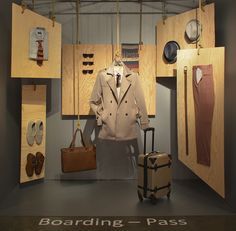 a display case with clothes and suitcases on the wall in front of it that says boarding - pass