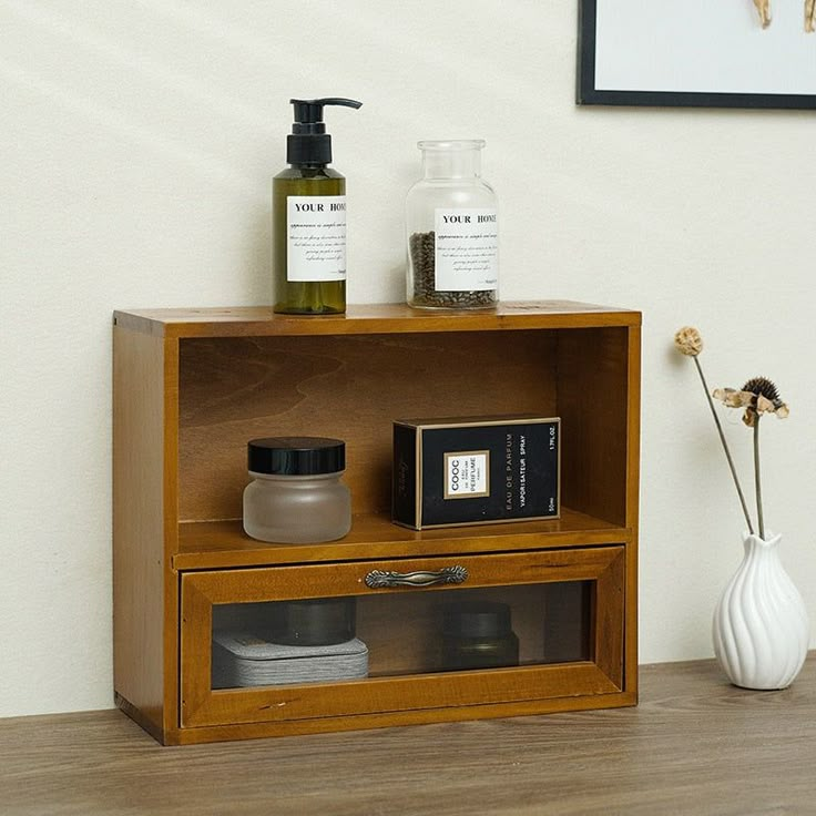 a wooden shelf with some bottles on top of it and a vase next to it