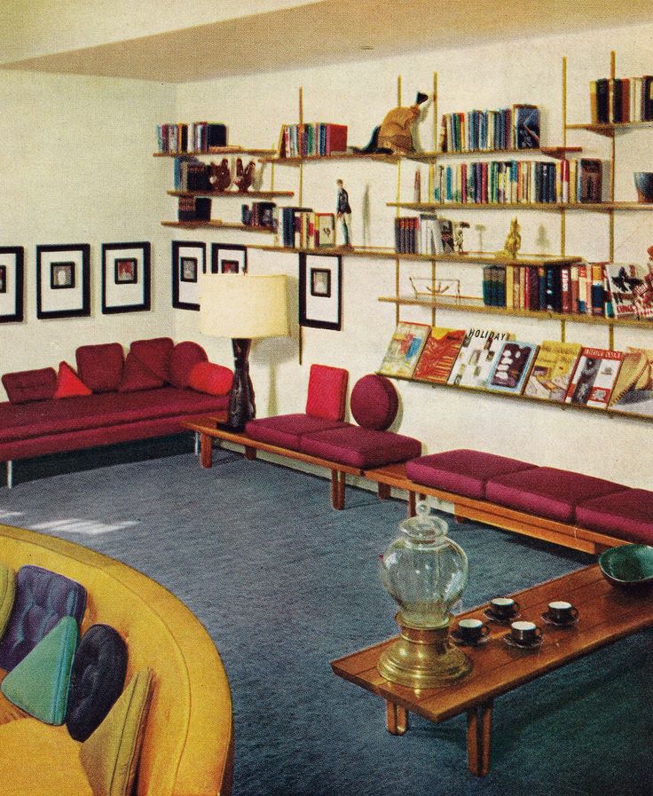 a living room filled with purple couches and lots of books on the shelves above them