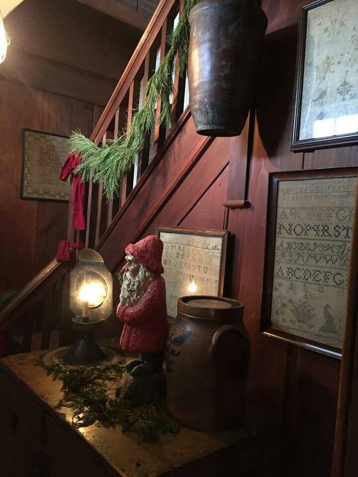 an old fashioned christmas decoration on top of a wooden table next to a stair case