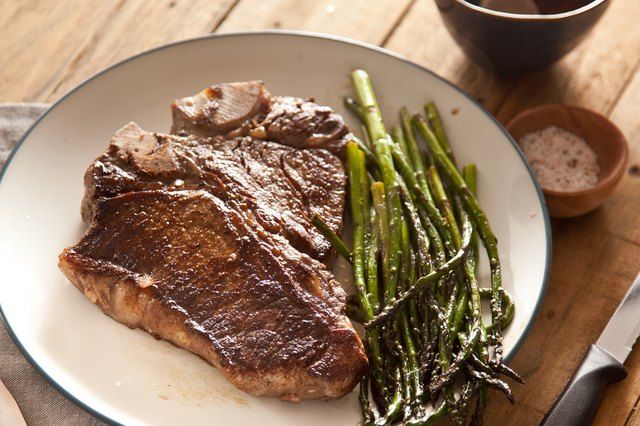 steak and asparagus on a white plate