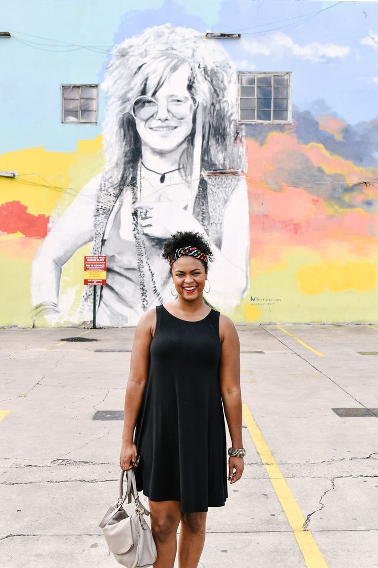 a woman standing in front of a mural