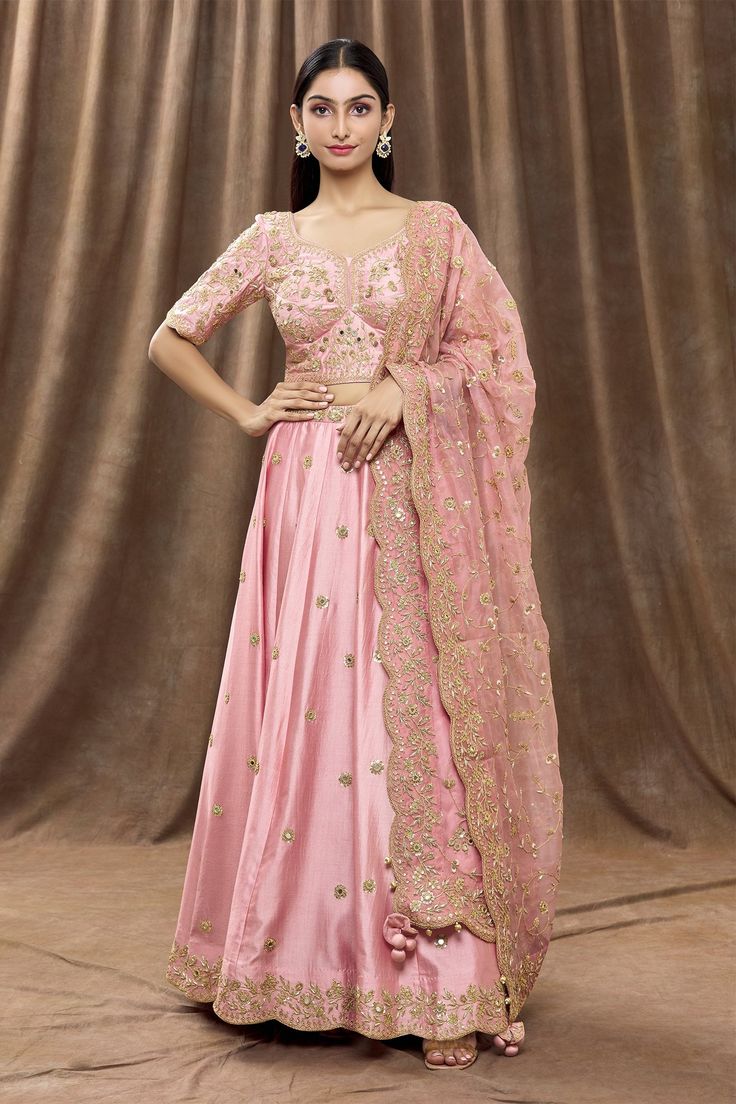 Rose gold lehenga with mirror, sequin embroidered floral motifs. Paired with floral embroidered blouse and dupatta.
Component: 3
Pattern: Embroidery
Type Of Work: Mirror, floral, sequin
Neckline: Leaf
Sleeve Type: Half
Fabric: Pure spun silk, pure organza
Color: Pink
Other Details: 
Scallop border
Tassel bordered sheer dupatta
Side and back tie-up detailing
Occasion: Destination Wedding - Aza Fashions Rose Gold Lehenga, Sheer Dupatta, Leaf Sleeve, Gold Lehenga, Embroidery Mirror, Scallop Border, Types Of Work, Pink Mirror, Luxury Sale