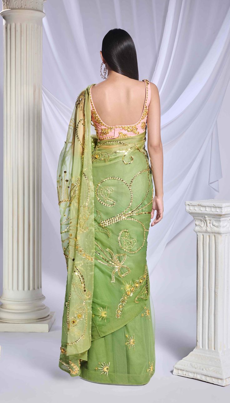 Introducing our moss green shaded sari, skillfully crafted from a blend of organza and tulle. The organza pallu is adorned with intricate gold embroidery, incorporating sequins, cut dana detailing, and gold metallics that narrate a charming tale with elements like flowers, butterflies, and hearts. The pre-stitched tulle bottom features scattered detailing with motifs of moons and stars. Completing the ensemble is a rose pink blouse featuring a straight neckline, adorned with elaborate golden chu Orange Organza Saree, Engagement Sarees, Reception Sarees, Papa Don't Preach, Green Sari, Haldi Dress, Tulle Blouse, Celebrity Closet, Bridal Jumpsuit