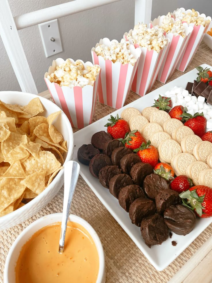 a table topped with plates of food and bowls of chips