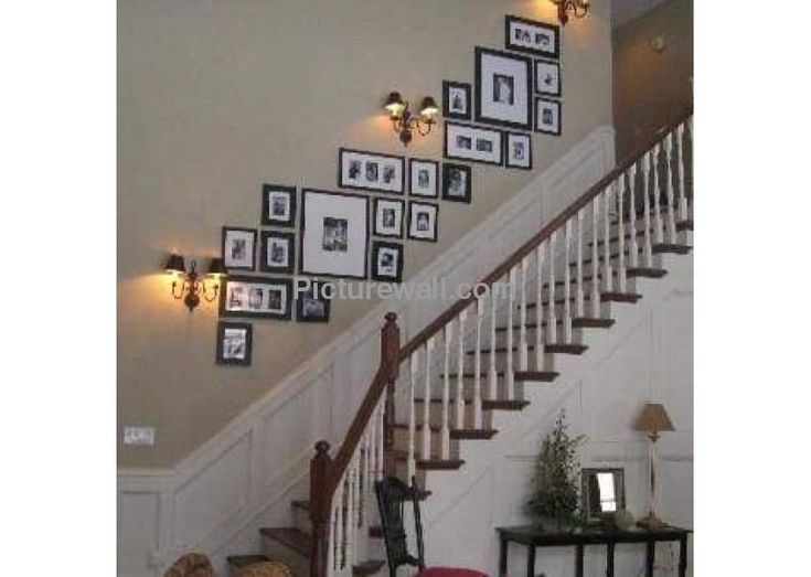 a staircase with pictures on the wall above it