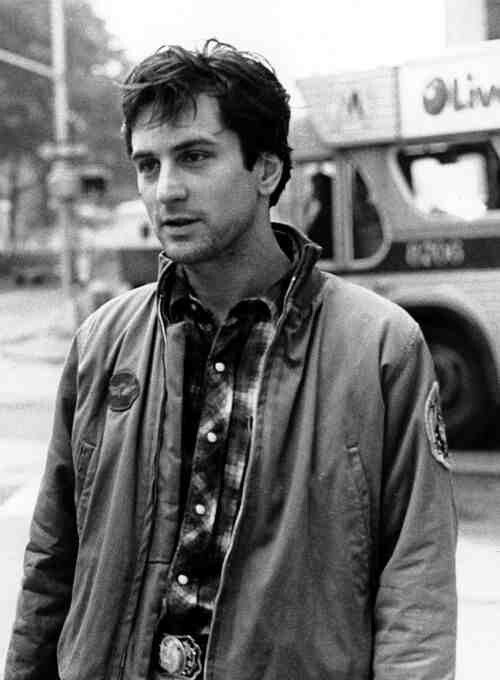 black and white photograph of man standing on street corner