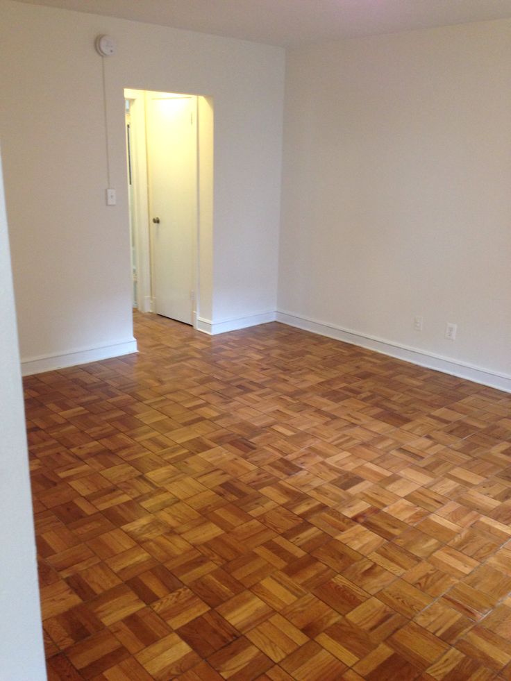 an empty room with hard wood floors and white walls