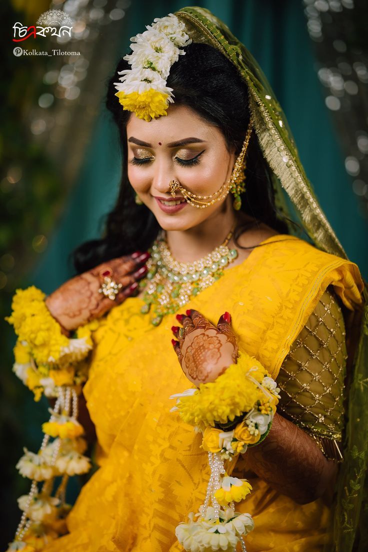 a woman in yellow is holding flowers and posing for the camera