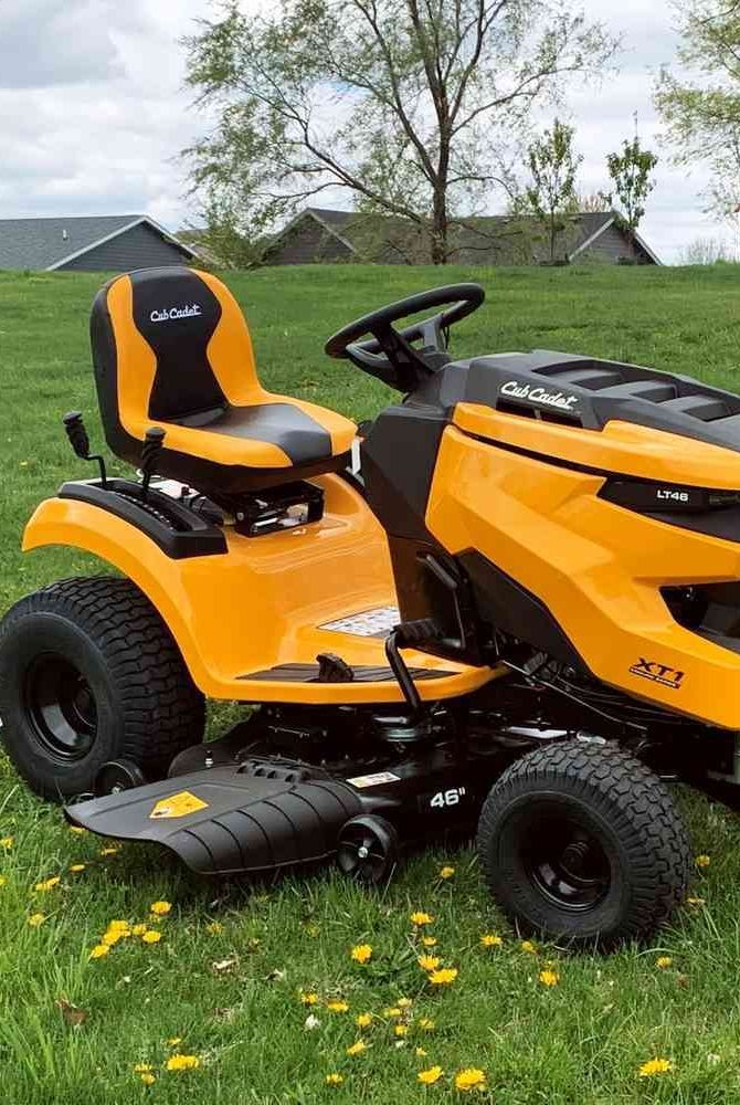 an orange lawn mower sitting in the grass