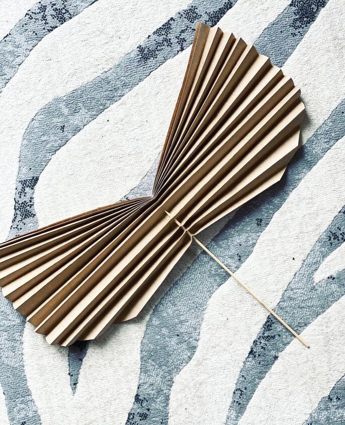 a close up of a wooden fan on a zebra print rug with pins sticking out of it