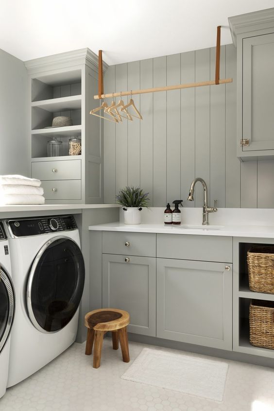 a washer and dryer in a room with gray cabinets, white counter tops and drawers