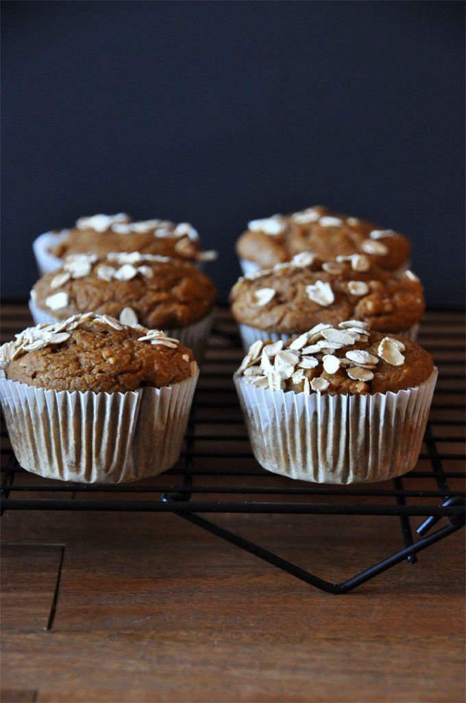 three muffins sitting on top of a cooling rack with oatmeal toppings