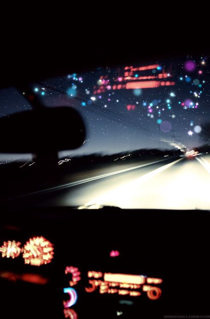 the dashboard of a car at night with lights on and blurry in the background