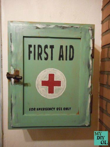 a green first aid sign mounted to the side of a wall