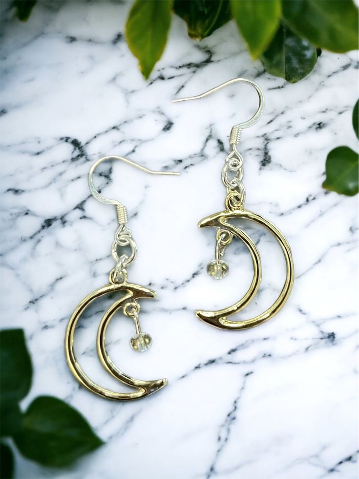 Crescent moon Dreamland Earrings 🌙 Free shipping! The moons have a slight rose gold tone, although they look pretty close to silver as well. They come with silver earring hooks, but I'm happy to add on gold hooks instead! Send me a message & let me know if you have a preference. Crafted with love 💖   Thank you for checking out LunaeLumina!  Feel free to message me if you have any questions! Gold Moon Charm Drop Earrings, Metal Drop Earrings With Moon Charm, Gold Drop Earrings With Moon Charm, Rose Gold Celestial Earrings, Hypoallergenic Silver Hoop Earrings In Brass, Celestial Moon Charm Metal Earrings, Celestial Metal Earrings With Moon Charm, Metal Moon Charm Earrings In Celestial Style, Celestial Moon Shaped Metal Earrings