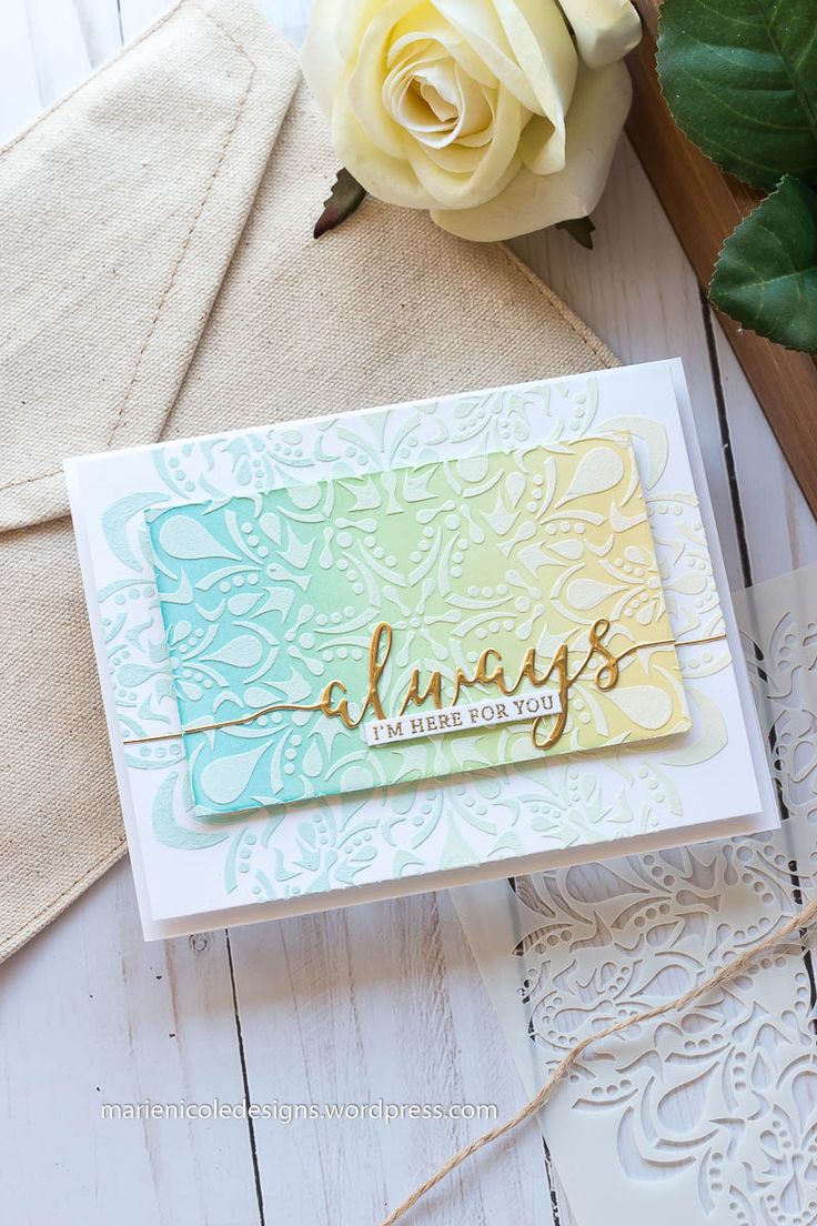 a close up of a card on a table next to a flower and some scissors