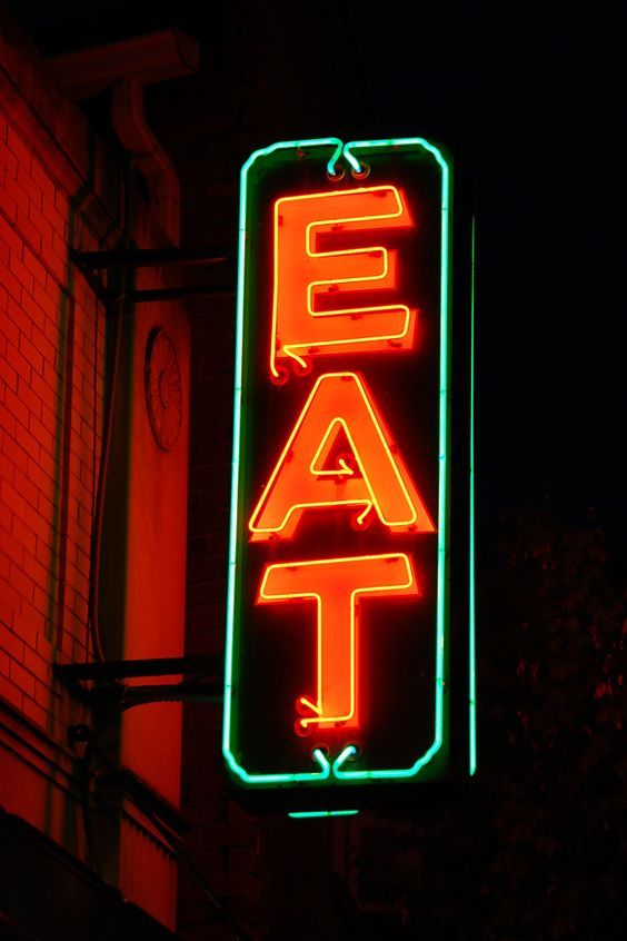 a neon sign that is on the side of a building