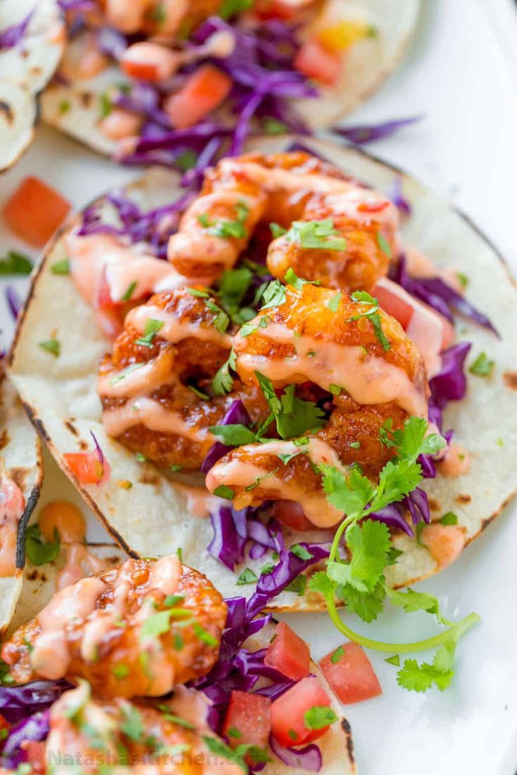 shrimp tacos with coleslaw and tomato slaw on a white platter