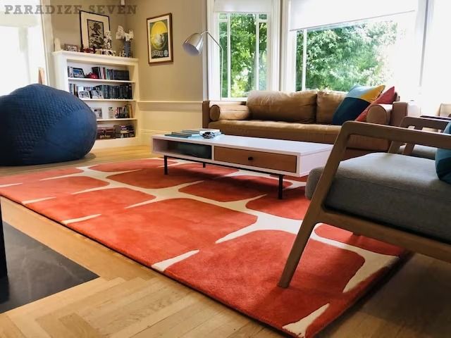 a living room filled with furniture and large windows