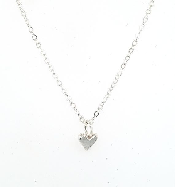 This is a tiny tiny little heart charm made out of solid sterling silver.  It is perfect for layering with other necklaces, or wear it on it's own for a nice and simple necklace.  It's perfect for a discrete and minimalist everyday necklace :)The photo on the neck form shows the charm on a 16" chain, however you can chose between 16", 18", or 20".I make all of my jewelry by hand in my Savannah, GA studio. Please contact me if you have any questions :) Minimalist Everyday Charm Necklace With Heart Charm, Dainty Everyday Heart Charm Necklace, Minimalist Everyday Charm Necklace With Heart, Minimalist Everyday Necklace With Heart Charm, Dainty Small Heart Necklace For Everyday, Dainty Heart Pendant Charm Necklace For Everyday, Dainty Everyday Heart Pendant Charm Necklace, Minimalist Nickel-free Heart Pendant Jewelry, Minimalist Nickel-free Heart-shaped Jewelry