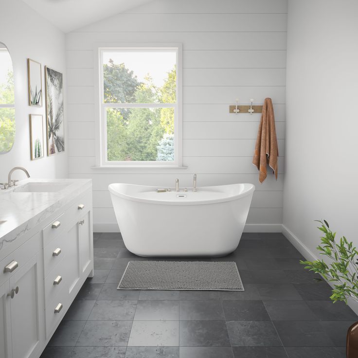 a white bath tub sitting under a window in a bathroom