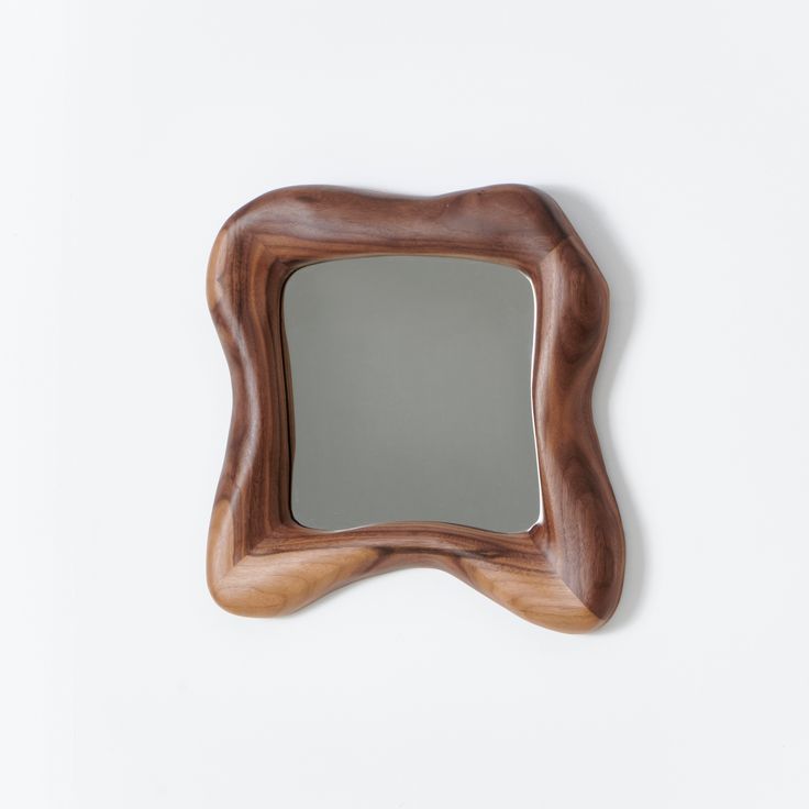 a mirror that is made out of wood and has a wooden frame on the wall