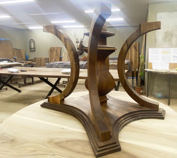 a wooden sculpture sitting on top of a table in a room filled with tables and chairs