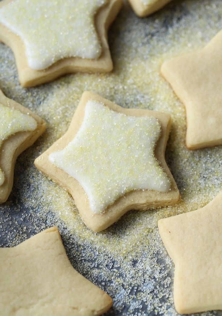 some sugar cookies with white icing and stars on the top are sitting on a baking sheet