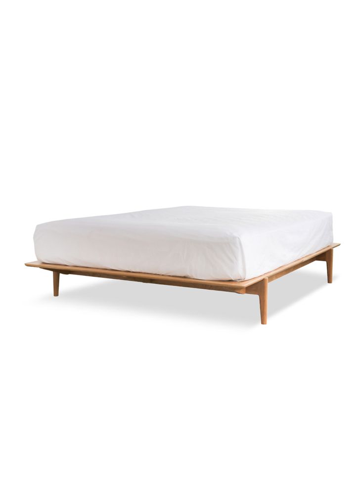 the bed frame is made from wood and has white sheets on it, with a wooden base