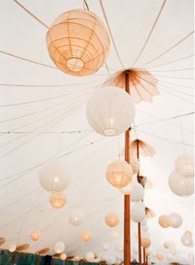 several paper lanterns hanging from the ceiling in a tent