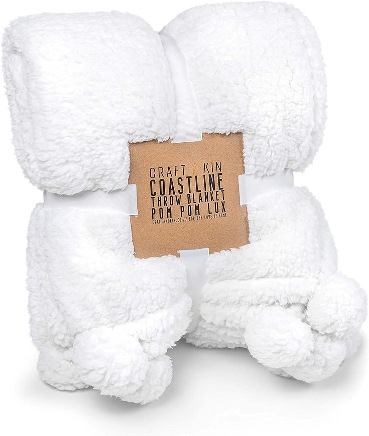 a white teddy bear with a tag on it's chest and its arms folded up