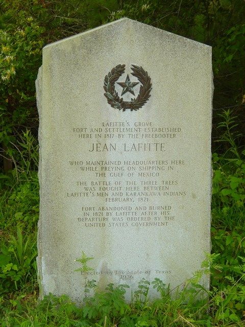 a monument in the grass with a star on it's head and wreath around its neck