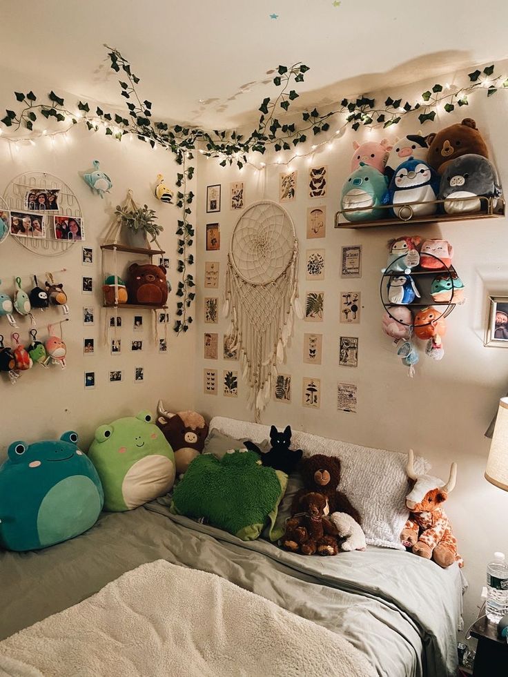 a bed with lots of stuffed animals on the headboard and pillows in front of it