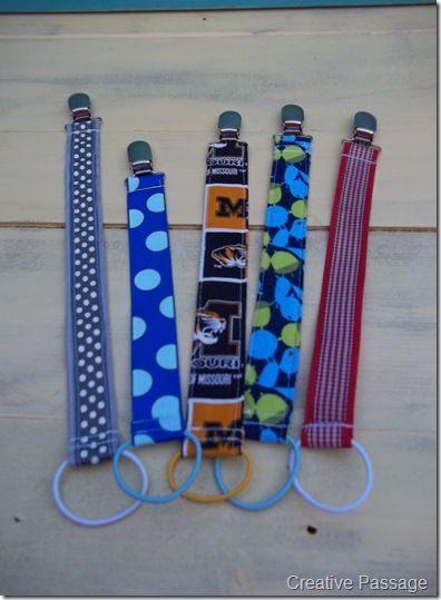 four lanyards are lined up on a wooden surface, each with different designs