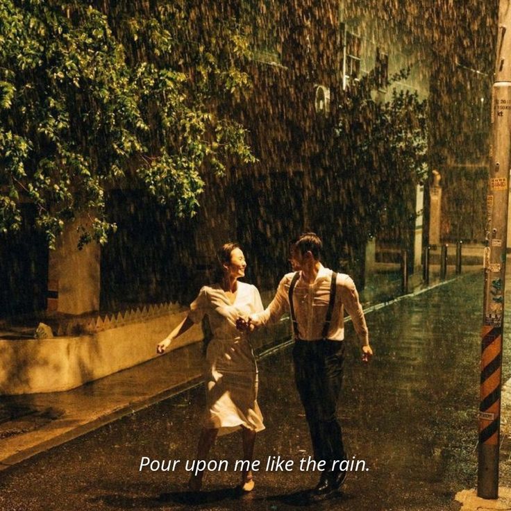 two people walking in the rain holding hands