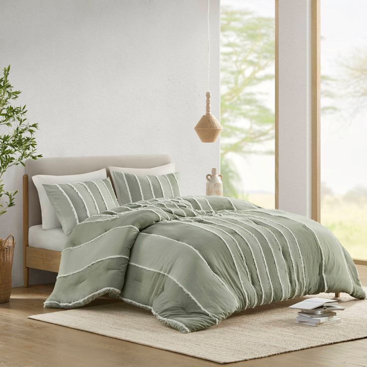 a bed in a room with a green comforter and pillows