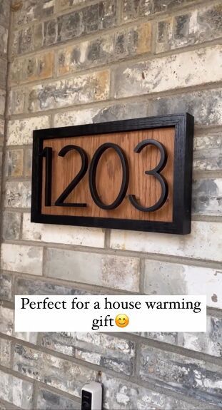 a sign that reads perfect for a house warming gift on the wall next to a brick wall