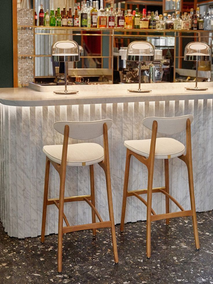 two bar stools sitting in front of a counter