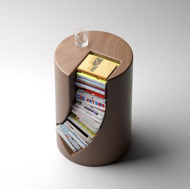 a stack of books sitting inside of a wooden container on top of a white table