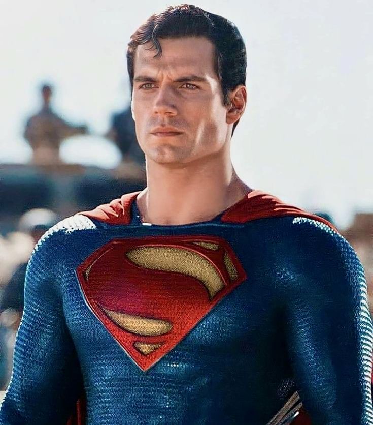 a close up of a superman figure wearing a blue and red suit with his hands in his pockets