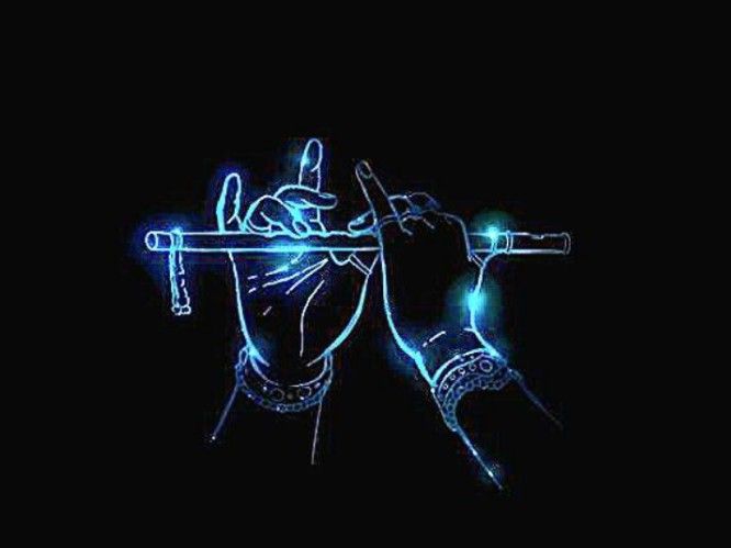 a hand holding a flute in the dark with blue light on it's side