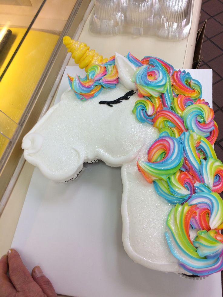 the cake is shaped like a unicorn's head with rainbow swirls on it