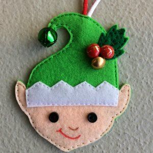 a felt ornament with a green elf's hat and bells on it