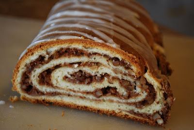 a cinnamon roll is cut in half on a cutting board